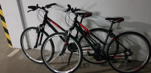 two bikes parked next to each other against a wall at Apartament green-balcony z parkingiem i rowerami in Świnoujście