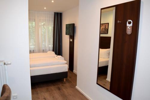 Habitación pequeña con cama y espejo. en Trip Inn Budget Hotel Messe en Frankfurt