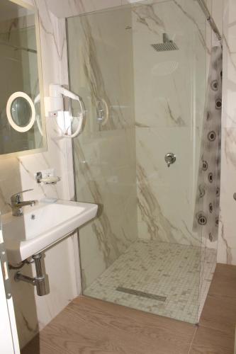 a bathroom with a sink and a shower at Palmanova Beach Mardok in Vlorë
