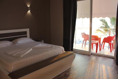a bedroom with a bed and a view of a patio at Palmanova Beach Mardok in Vlorë