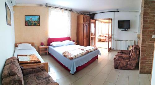 a bedroom with two beds and a tv and a couch at Guest House Julia in Senj
