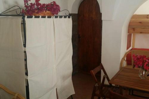 a room with a white curtain and a table at A Kasuzza in Pantelleria