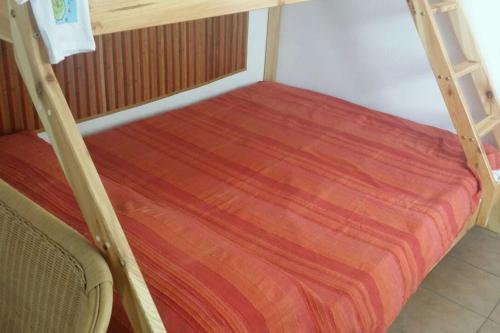 a bedroom with a bunk bed with a orange bedspread at A Kasuzza in Pantelleria