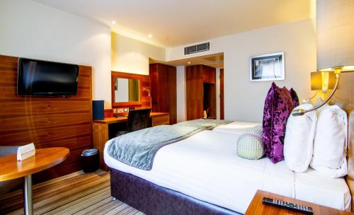 a hotel room with a bed and a television at Blakemore Hyde Park in London