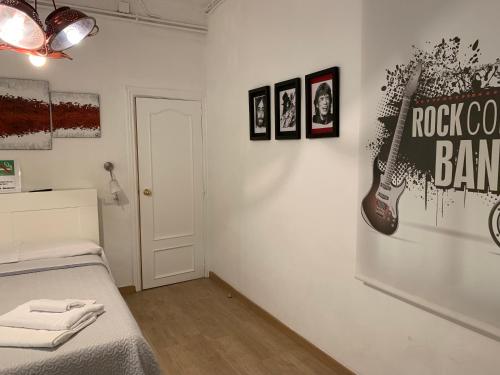a bedroom with a bed and pictures on the wall at Hostal Portugal in Barcelona