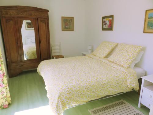 a bedroom with a bed and a wooden cabinet at Lemoniegites in Lemonie