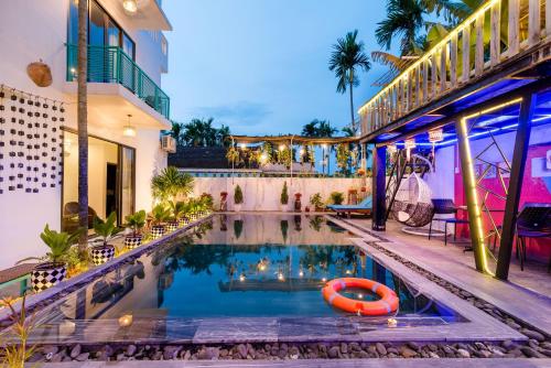 a pool in the middle of a building with a red raft in the water at Sunny Riverside Homestay in Hoi An