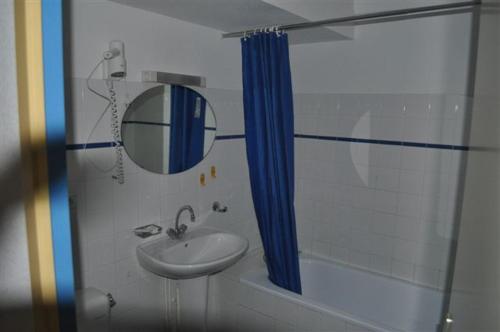 a bathroom with a sink and a mirror and a shower at Domaine du Lac Ferrand in Saint-Cirgues-en-Montagne