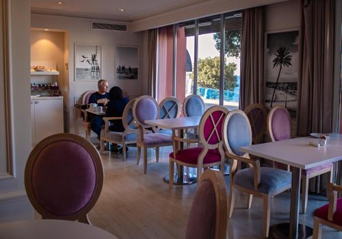 
a man sitting at a table in a restaurant at Hotel Suisse in Nice
