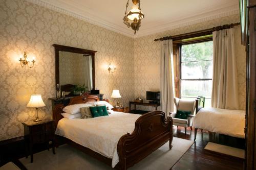 a bedroom with a bed and a mirror and a window at Elm Grove Country House in Tenby