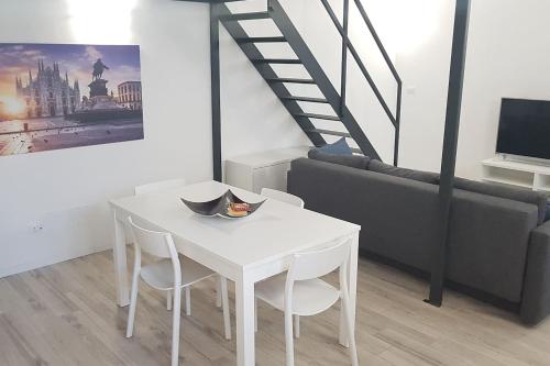 uma mesa branca e cadeiras numa sala de estar em Solari7 em Milão