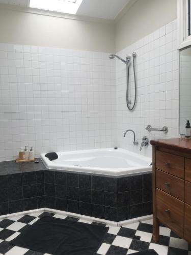 a bathroom with a tub with a shower and a sink at Lotti's House in Albany