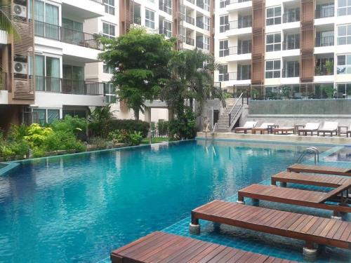 a swimming pool with benches in a building at Diamond Suite in Pattaya South