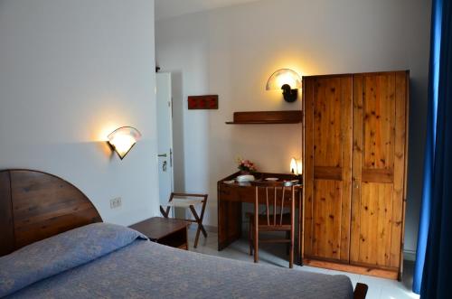 a bedroom with a bed and a desk and a table at Hotel La Gioiosa in Finale Ligure