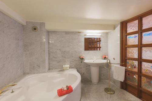 une salle de bain avec une baignoire blanche et un lavabo dans l'établissement Quai des Marinières AP2015 by Riviera Holiday Homes, à Villefranche-sur-Mer