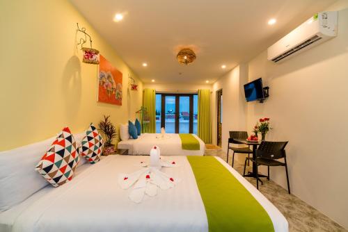 a hotel room with two beds and a desk at Sunny Riverside Homestay in Hoi An