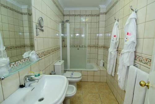 ein Badezimmer mit einem Waschbecken, einem WC und einer Badewanne in der Unterkunft Villamar Hotel in Morro del Jable