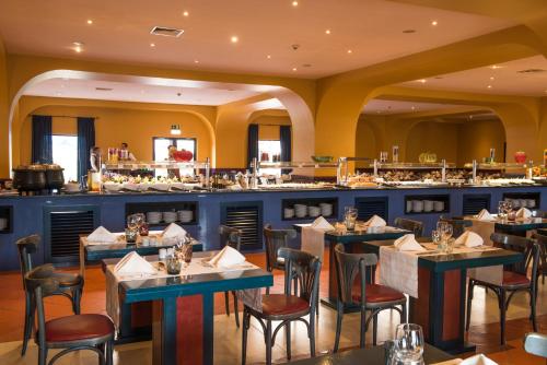a dining room with tables and a bar at Vila Gale Tavira in Tavira