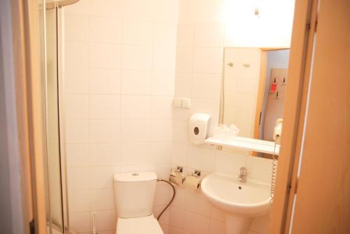 a small bathroom with a toilet and a sink at Economy Silesian Hotel in Katowice