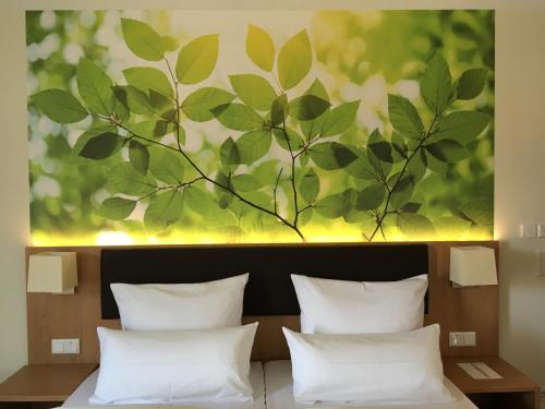 a painting above a bed with white pillows at INhouse - Wohnen auf Zeit in Ingolstadt