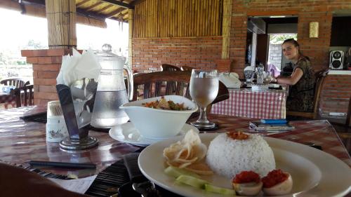een tafel met een bord rijst en een kom eten bij Kubu Taru in Sidemen