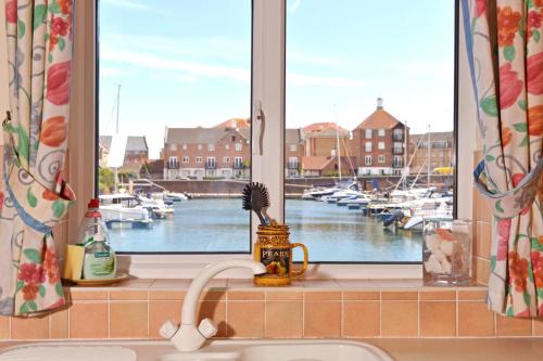 a kitchen window with a view of a marina at Sail Away in Eastbourne