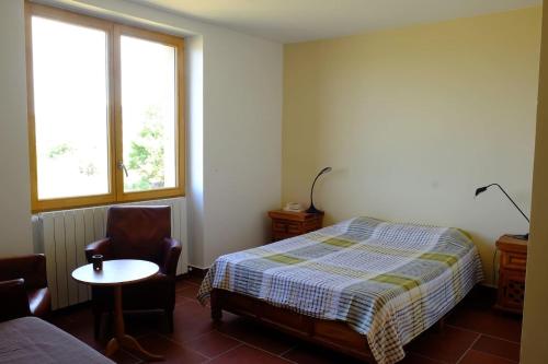 Un dormitorio con una cama, una mesa y una silla. en Chez la Nonna, en Saint-Jean-le-Centenier