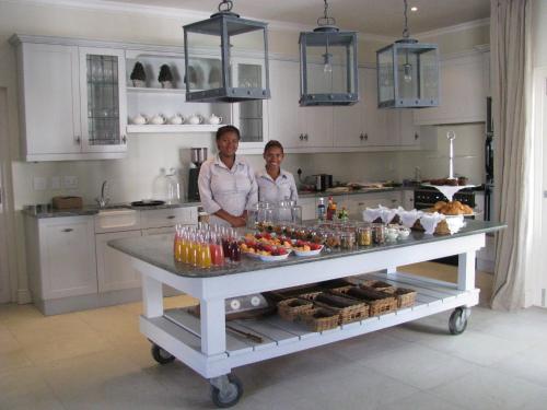 two women standing behind a buffet in a kitchen at Maison d'Ail Guest House in Franschhoek