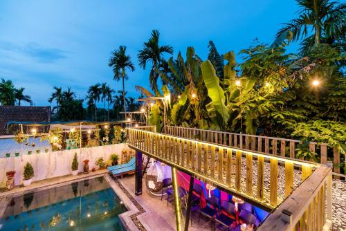 a view of a resort with a pool at night at Sunny Riverside Homestay in Hoi An