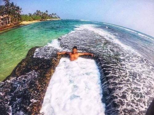 un hombre yaciendo en el agua en el océano en Khongaha Villa Holiday Home, en Mirissa