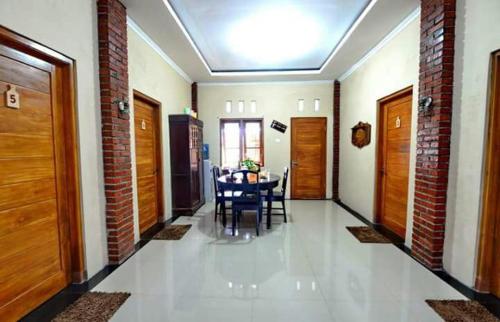 um corredor com uma mesa e cadeiras numa casa em nDalem Eyang Dwijo em Yogyakarta