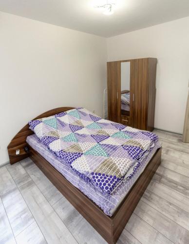um quarto com uma cama com uma colcha em Apartamen Lux em Sandanski