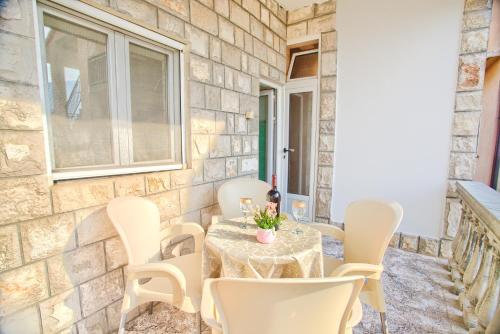 un patio amurallado de piedra con mesa y sillas en Apartment Vladan, en Kotor