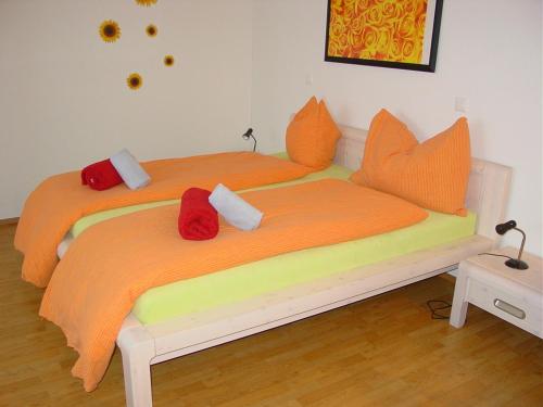 1 Schlafzimmer mit 2 Betten und orangefarbenen Kissen in der Unterkunft Gasthof Raben in Eschenz