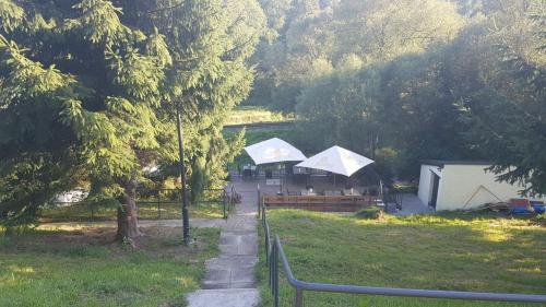 two white umbrellas in a park with trees at Olivin Kytlice Hiker Huts in Kytlice