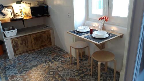 a small kitchen with a table and two stools at Hostel A Casa da Árvore in Faro