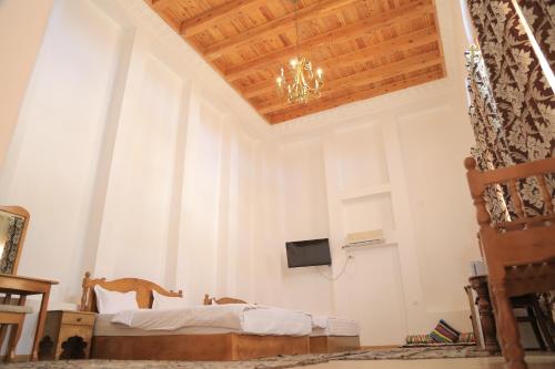 um quarto com uma cama e um lustre em As-Salam Boutique Hotel em Bukhara