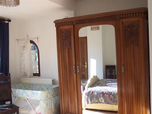 - une chambre avec un lit et une grande armoire en bois dans l'établissement Bastide Provencal, à Théoule-sur-Mer