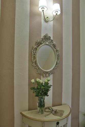 a vase of flowers on a table with a mirror at Irida Apartments in Leptokaria