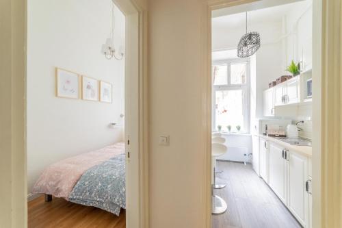 a white bedroom with a bed and a sink at Rumbach Residence in Budapest