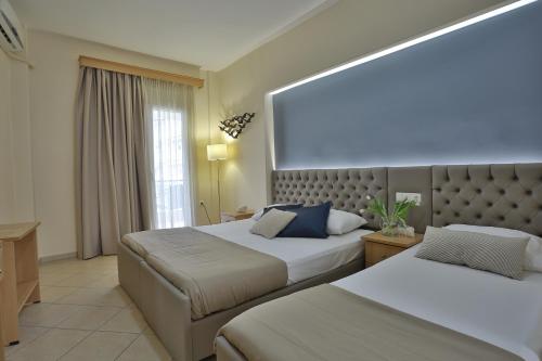 pokój hotelowy z 2 łóżkami i dużym oknem w obiekcie Irida Apartments w mieście Leptokaria