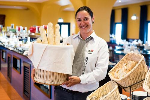 una mujer está sosteniendo una cesta de comida en Vila Gale Tavira, en Tavira