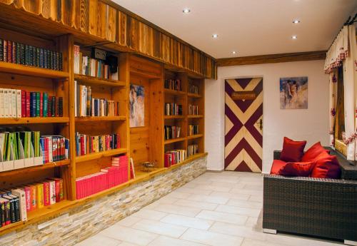 a library with wooden shelves filled with books at Hotel-Pension Egger in Grossarl
