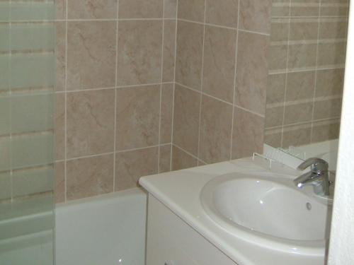 une salle de bain avec un lavabo et une baignoire dans l'établissement Lagrange Vacances Les Bastides des Chaumettes, à Montauroux