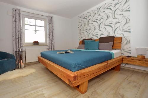 a bedroom with a large wooden bed with blue sheets at Ankerplatz Zingst in Zingst
