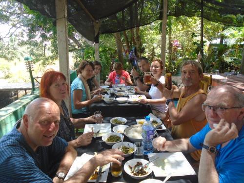 a group of people sitting at a table eating at Green Garden Homestay in Giritale