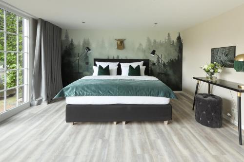 a bedroom with a bed with a green comforter at Meinsbur Boutique Hotel in Bendestorf