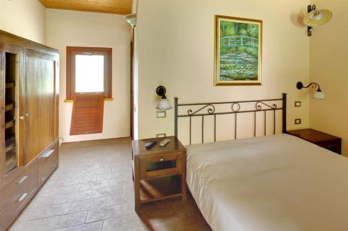 a bedroom with a bed with a night stand and a window at Agriturismo Cascina Madonnina in Pregnana Milanese