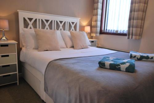 a bedroom with a large white bed with pillows at 11 Laigh Isle in Isle of Whithorn