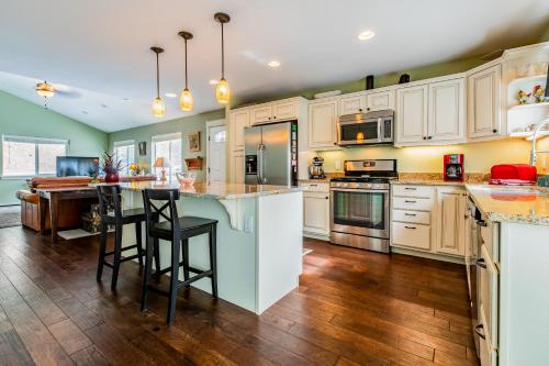 a kitchen with white cabinets and a island with bar stools at Bigfork Lake Getaway in Bigfork